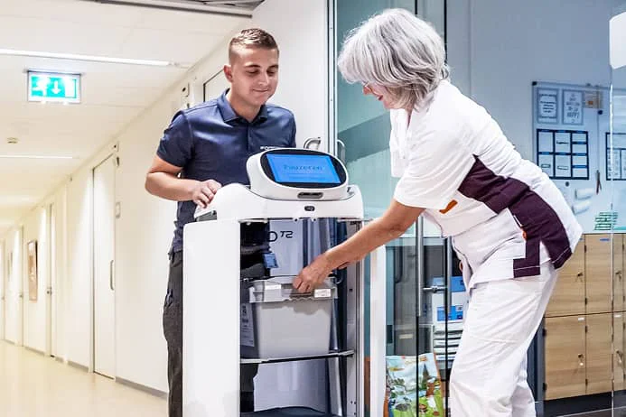 nurses in a hospital setting using a robot to perform work duties