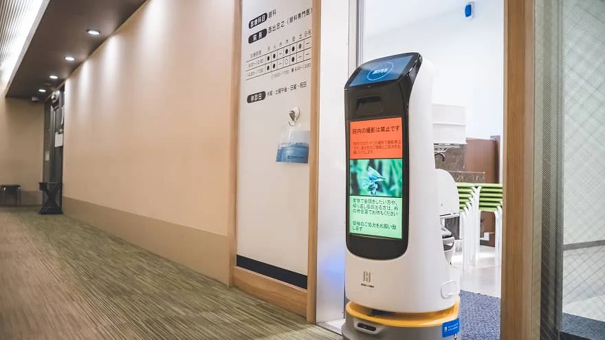 nurse looking at robot in clinic setting