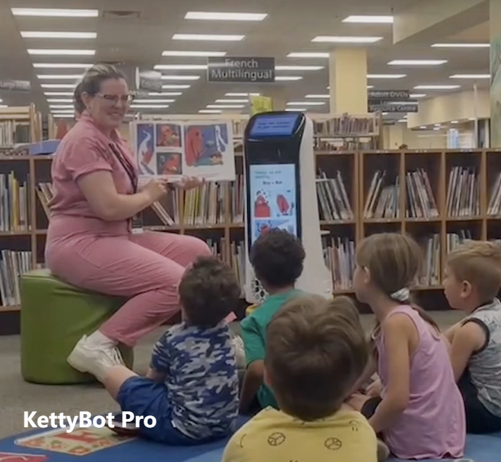 kettybot in a library setting with teacher and children