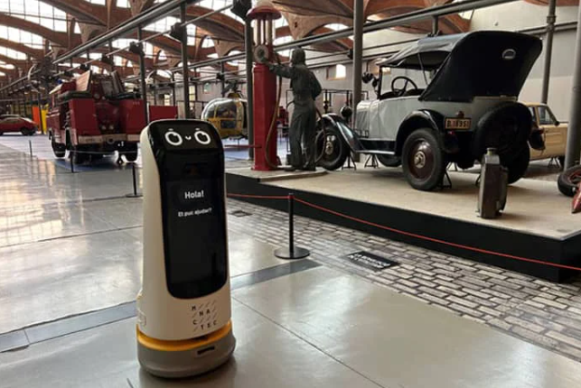 kettybot in a museum with old cars